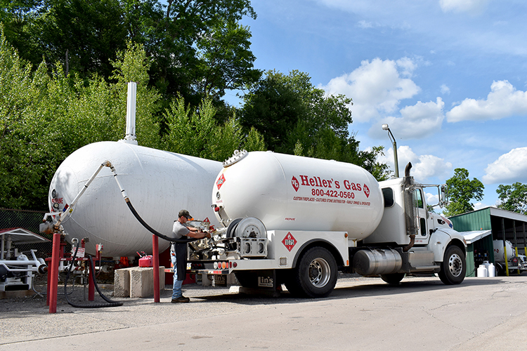 an employee filling up a propane tank to be delivered