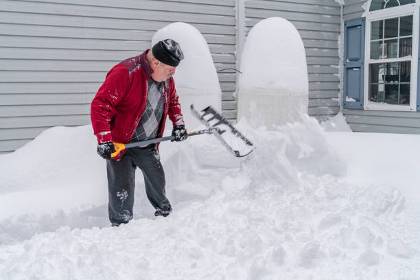 Senior retired Caucasian White man cleaning the snow around his home after the winter snowstorm.